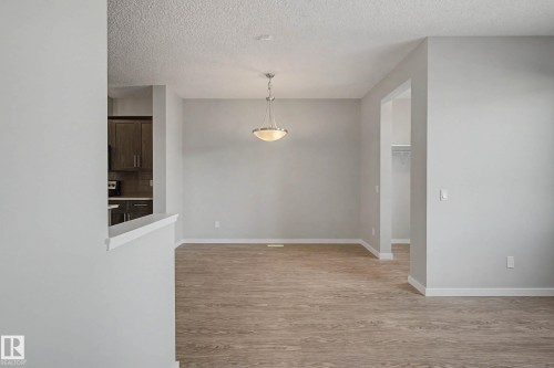 Unfurnished dining area featuring a textured ceiling and light wood finished floors - 2577 Coughlan Road, Edmonton, AB - Indoor Photo Showing Other Room