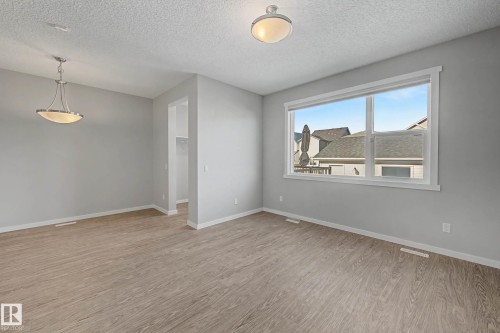 Unfurnished room featuring a textured ceiling and light wood-style flooring - 2577 Coughlan Road, Edmonton, AB - Indoor Photo Showing Other Room