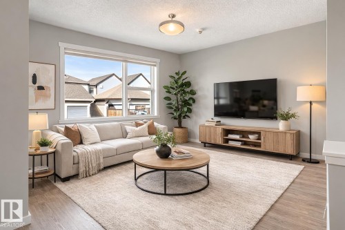 Living area featuring light wood-type flooring and a textured ceiling - 2577 Coughlan Road, Edmonton, AB - Indoor Photo Showing Living Room