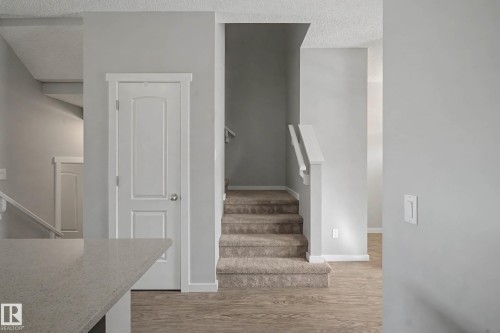 Stairs featuring a textured ceiling and wood finished floors - 2577 Coughlan Road, Edmonton, AB - Indoor Photo Showing Other Room