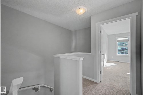 Hallway with light colored carpet, a textured ceiling, and an upstairs landing - 2577 Coughlan Road, Edmonton, AB - Indoor Photo Showing Other Room