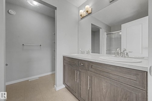 Bathroom featuring a textured ceiling, double vanity, and a shower stall - 2577 Coughlan Road, Edmonton, AB - Indoor Photo Showing Bathroom
