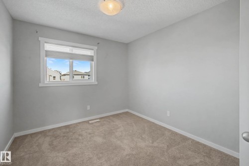 Empty room featuring light carpet and a textured ceiling - 2577 Coughlan Road, Edmonton, AB - Indoor Photo Showing Other Room