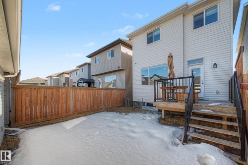 Snow covered house with a fenced backyard and a deck - 2577 Coughlan Road, Edmonton, AB - Outdoor With Exterior
