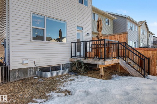 Snow covered rear of property with stairs and a deck - 2577 Coughlan Road, Edmonton, AB - Outdoor With Exterior