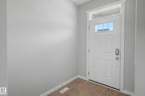 Foyer entrance featuring baseboards and wood finished floors - 2577 Coughlan Road, Edmonton, AB - Indoor Photo Showing Other Room