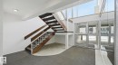 Stairs with a textured wall, a high ceiling, and tile patterned flooring - 103 1624 48 Street, Edmonton, AB  - Indoor Photo Showing Other Room 