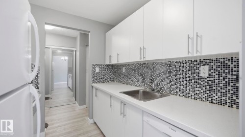 Kitchen with white appliances, white cabinets, light countertops, and tasteful backsplash - 103 1624 48 Street, Edmonton, AB - Indoor Photo Showing Kitchen With Upgraded Kitchen