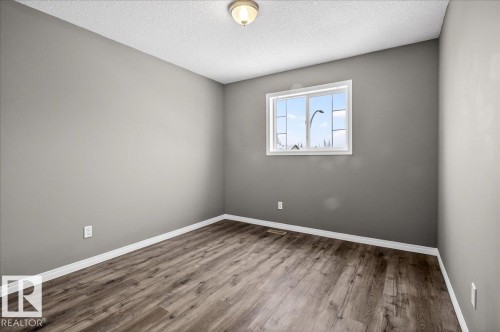 Empty room featuring wood finished floors and a textured ceiling - 150 Acacia Circle, Leduc, AB - Indoor Photo Showing Other Room