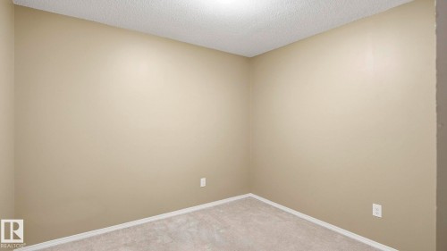 Empty room featuring a textured ceiling and light carpet - 319 274 Mcconachie Drive, Edmonton, AB - Indoor Photo Showing Other Room