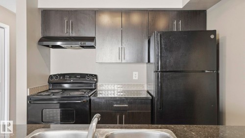 Kitchen featuring black appliances and dark wood finish cabinetry - 319 274 Mcconachie Drive, Edmonton, AB - Indoor Photo Showing Kitchen