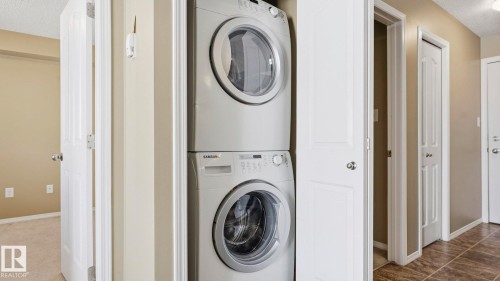 Laundry area featuring a textured ceiling and stacked washer / drying machine - 319 274 Mcconachie Drive, Edmonton, AB - Indoor Photo Showing Laundry Room
