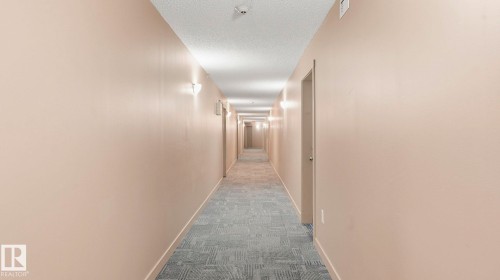 Hall featuring dark colored carpet and a textured ceiling - 319 274 Mcconachie Drive, Edmonton, AB - Indoor Photo Showing Other Room