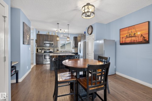 Dining room featuring dark wood-style flooring and a textured ceiling - 7074 Cardinal Way, Edmonton, AB - Indoor