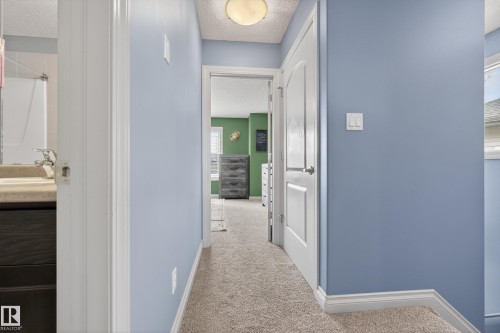 Hall featuring a textured ceiling and light carpet - 7074 Cardinal Way, Edmonton, AB - Indoor Photo Showing Other Room