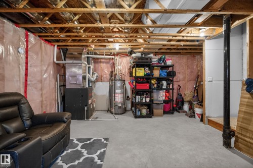 Unfinished below grade area featuring heating unit and gas water heater - 7074 Cardinal Way, Edmonton, AB - Indoor Photo Showing Basement