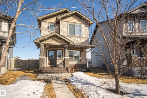 Craftsman inspired home featuring a gate, covered porch, and stone siding - 7074 Cardinal Way, Edmonton, AB - Outdoor With Facade