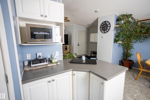 The kitchen offers white cabinetry, a built-in microwave, and a gray countertop - 41 Graywood Cove, Stony Plain, AB - Indoor Photo Showing Kitchen