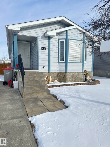 The property features light blue siding, a covered porch entry, and a bay window - 41 Graywood Cove, Stony Plain, AB - Outdoor