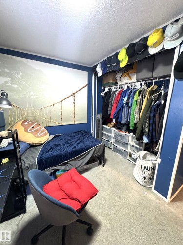 Bedroom featuring a textured ceiling, light carpet, and a closet - 41 Graywood Cove, Stony Plain, AB - Indoor