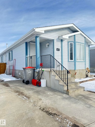 This property features light blue siding, a white front door, and a bay window with blinds - 41 Graywood Cove, Stony Plain, AB - Outdoor