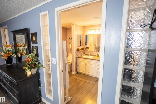 Bathroom featuring a double vanity with a light-colored countertop, white cabinetry, and wood-style flooring - 41 Graywood Cove, Stony Plain, AB - Indoor Photo Showing Bathroom