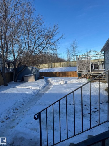 Snowy yard with a fenced backyard and a deck - 41 Graywood Cove, Stony Plain, AB - Outdoor