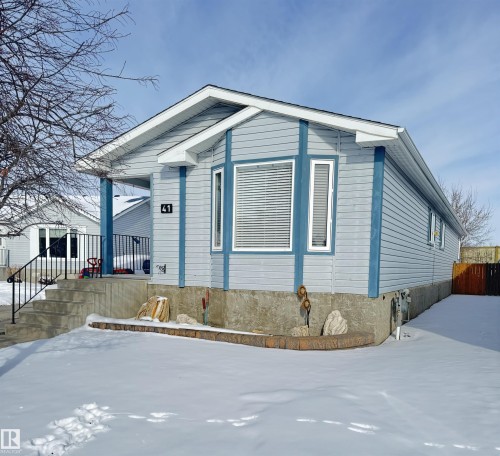 The property features light blue siding with darker blue trim and white window frames - 41 Graywood Cove, Stony Plain, AB - Outdoor