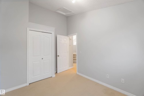 Unfurnished bedroom featuring light carpet, a closet, and a textured ceiling - 20604 48 Avenue, Edmonton, AB - Indoor Photo Showing Other Room