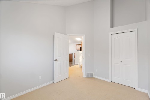 Unfurnished bedroom with light carpet, a high ceiling, and a closet - 20604 48 Avenue, Edmonton, AB - Indoor Photo Showing Other Room