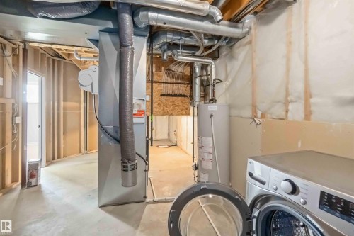 Unfinished basement featuring washer / dryer, water heater, and heating unit - 20604 48 Avenue, Edmonton, AB - Indoor Photo Showing Laundry Room
