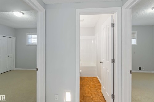 Corridor featuring a textured ceiling and light colored carpet - 20604 48 Avenue, Edmonton, AB - Indoor Photo Showing Other Room