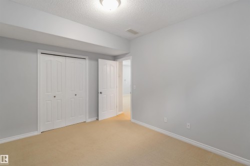 Unfurnished bedroom with light carpet, a closet, and a textured ceiling - 20604 48 Avenue, Edmonton, AB - Indoor Photo Showing Other Room