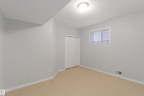 Unfurnished bedroom with light colored carpet, a textured ceiling, and a closet - 20604 48 Avenue, Edmonton, AB - Indoor Photo Showing Other Room