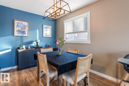 Dining room featuring hanging lights, wood finished floors, and a textured ceiling - 14 Lester Crescent, St. Albert, AB - Indoor Photo Showing Dining Room