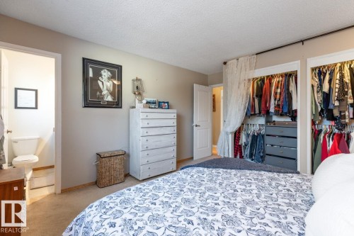 Bedroom featuring light colored carpet, a textured ceiling, and a closet - 14 Lester Crescent, St. Albert, AB - Indoor Photo Showing Bedroom