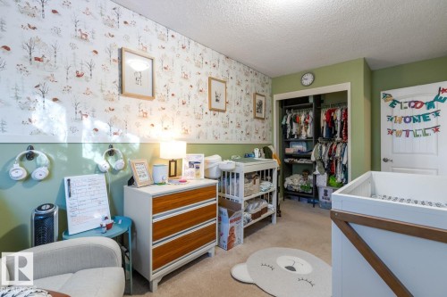 Bedroom with wallpapered walls, light carpet, a closet, and a textured ceiling - 14 Lester Crescent, St. Albert, AB - Indoor