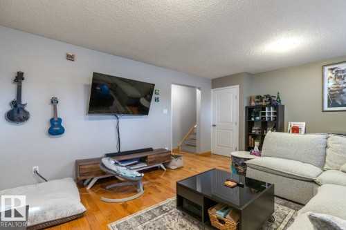Living area with a textured ceiling and light wood-style floors - 14 Lester Crescent, St. Albert, AB - Indoor Photo Showing Living Room