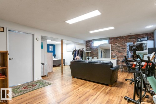 Living area featuring light wood-type flooring and brick wall - 14 Lester Crescent, St. Albert, AB - Indoor