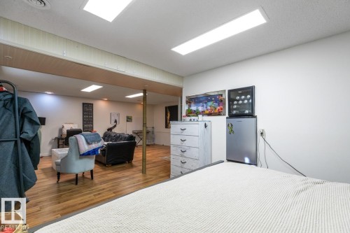Bedroom featuring wood finished floors and stainless steel fridge - 14 Lester Crescent, St. Albert, AB - Indoor