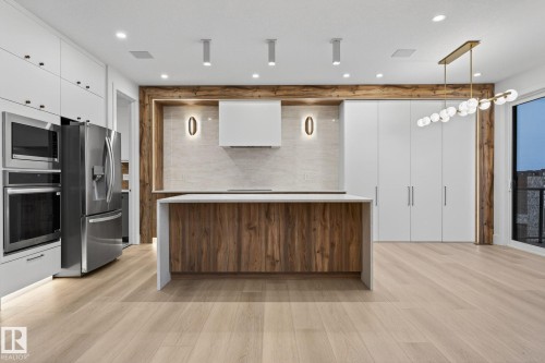 Kitchen featuring a center island, stainless steel appliances, modern cabinets, dual tone cabinetry, and hanging light fixtures - 8765 Mayday Lane, Edmonton, AB - Indoor Photo Showing Kitchen With Upgraded Kitchen