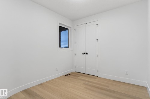 Unfurnished bedroom featuring light wood finished floors and a closet - 8765 Mayday Lane, Edmonton, AB - Indoor Photo Showing Other Room