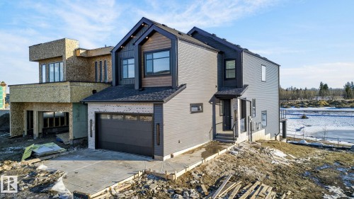 View of front of property featuring a garage and a shingled roof - 8765 Mayday Lane, Edmonton, AB - Outdoor
