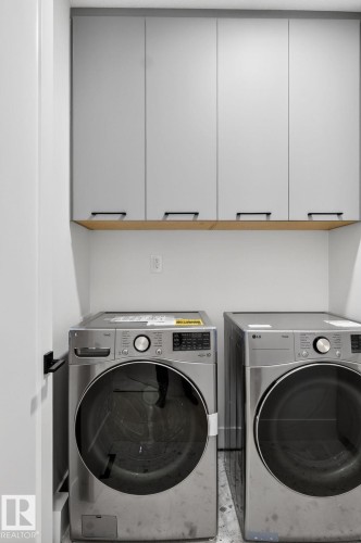 Laundry area with cabinet space and washing machine and clothes dryer - 8765 Mayday Lane, Edmonton, AB - Indoor Photo Showing Laundry Room