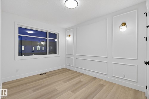 Spare room with a decorative wall and light wood-style flooring - 8765 Mayday Lane, Edmonton, AB - Indoor Photo Showing Other Room