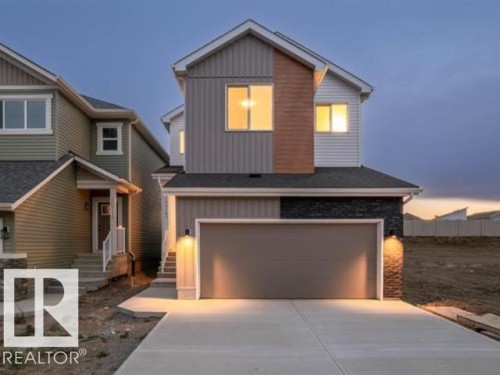 Modern home with board and batten siding, driveway, an attached garage, and stone siding - 20723 24 Avenue, Edmonton, AB - Outdoor