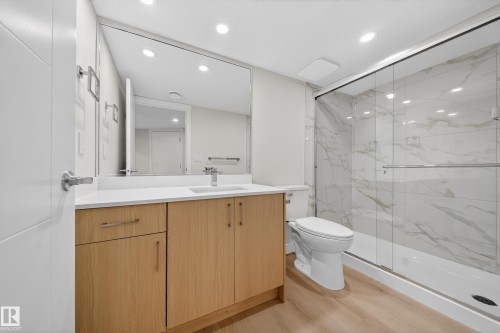 Bathroom with vanity, a marble finish shower, light wood-type flooring, and recessed lighting - 20723 24 Avenue, Edmonton, AB - Indoor Photo Showing Bathroom