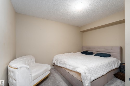Bedroom with carpet floors and a textured ceiling - 205 340 Windermere Road, Edmonton, AB - Indoor Photo Showing Bedroom