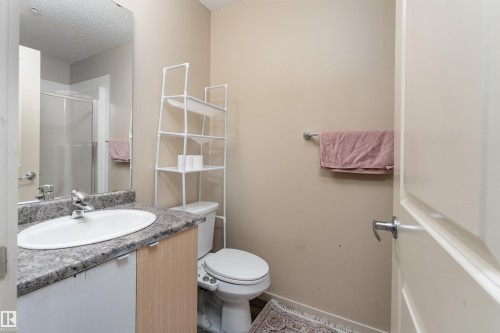 Bathroom featuring vanity, a shower stall, and a textured ceiling - 205 340 Windermere Road, Edmonton, AB - Indoor Photo Showing Bathroom