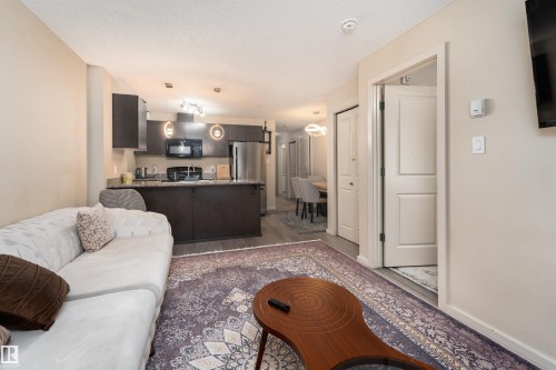 Living room with light wood finished floors and baseboards - 205 340 Windermere Road, Edmonton, AB - Indoor
